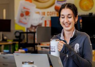 Nestle employee holding coffee mug while working