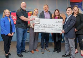 Nestle employees holding $100,000 check