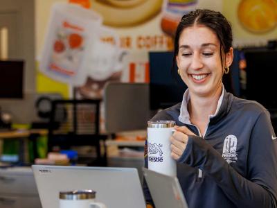 Nestle employee holding coffee mug while working