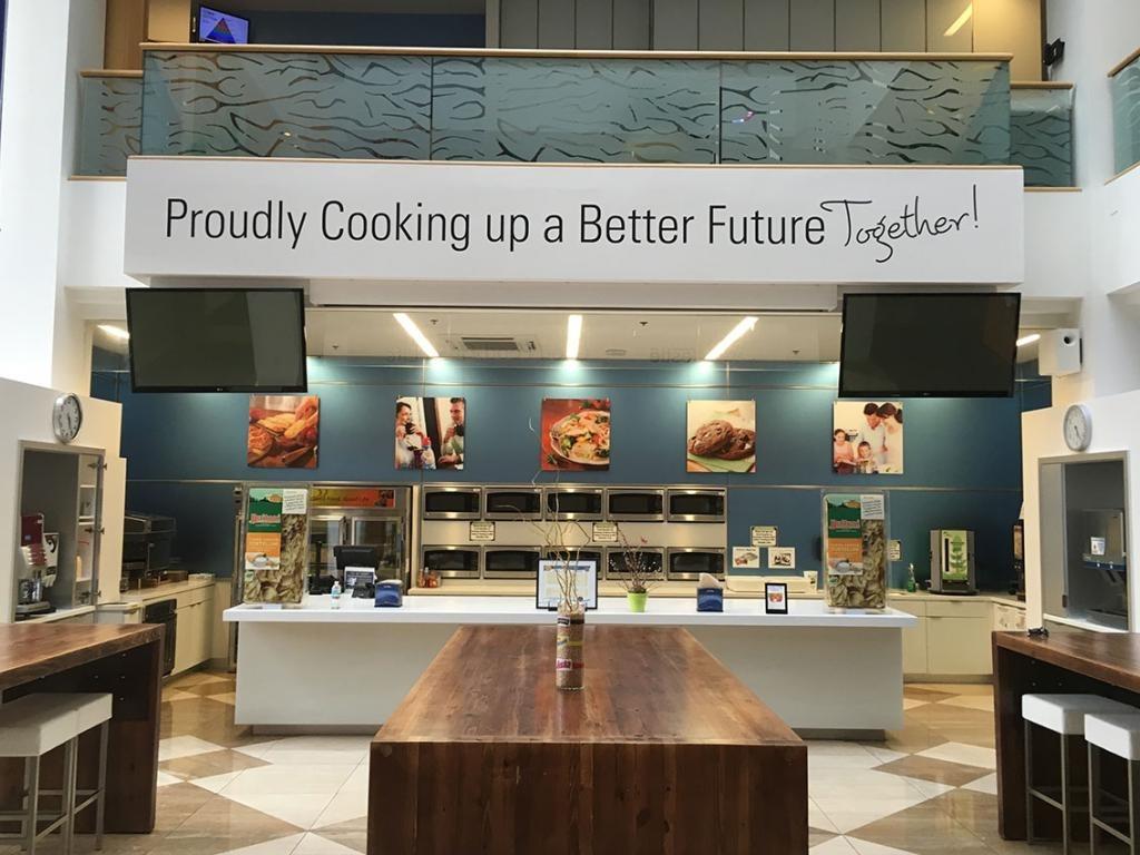 Modern Nestlé Solon kitchen with ovens and “Cooking up a Better Future” sign