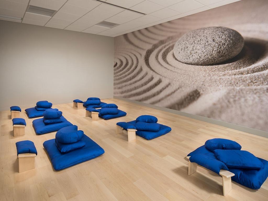 Meditation room with blue cushions, wooden benches, and Zen garden mural