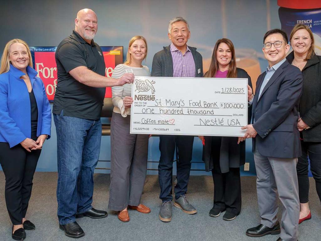 Nestle employees holding $100,000 check
