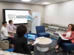 Team meeting in modern office with Nestlé logo on screen and whiteboard