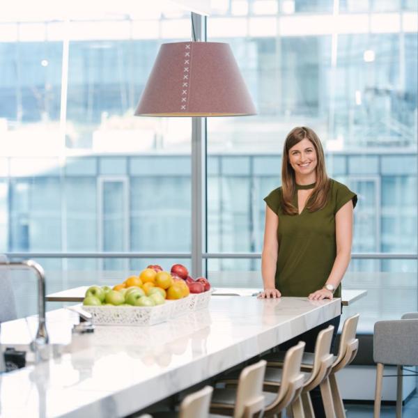 Woman standing in office building smiling at camera
