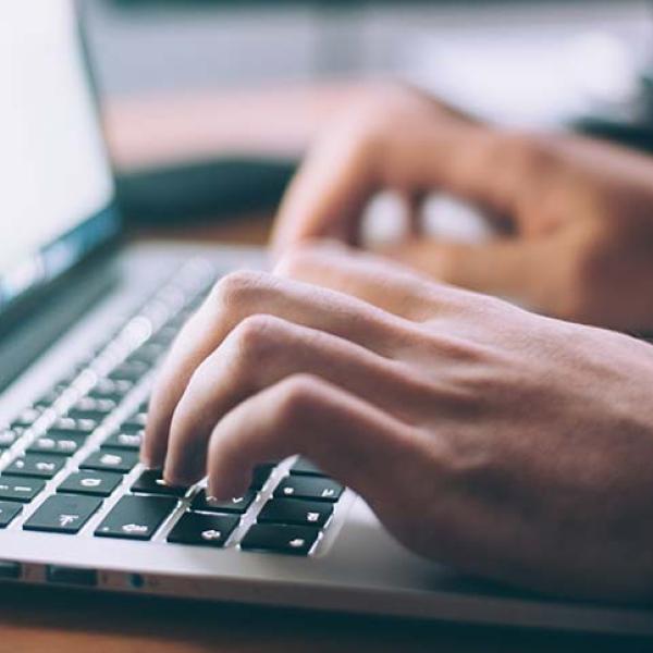 Person typing on their laptop