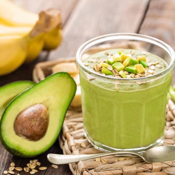 Avocado resting next to a cup of pudding