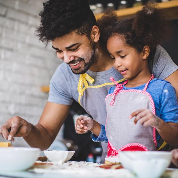 Father and daughter making a pizza together