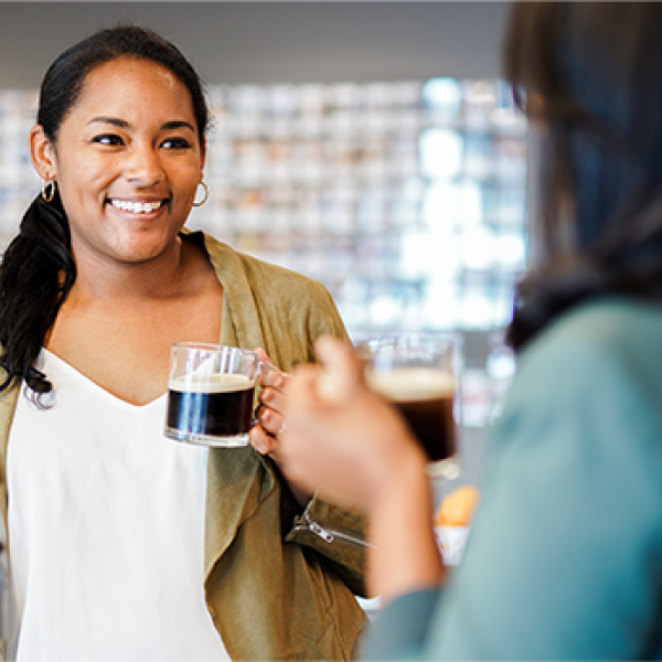 Two female Nestle employees drinking Nespresso talking and smiling