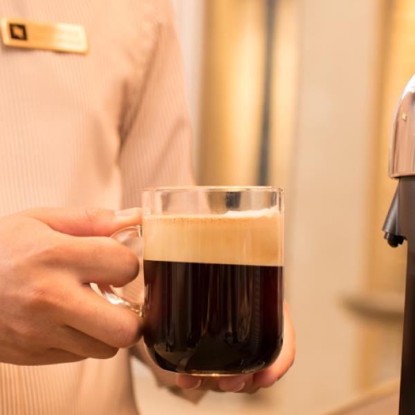 Close up holding glass of Nespresso Close up holding glass of Nespresso