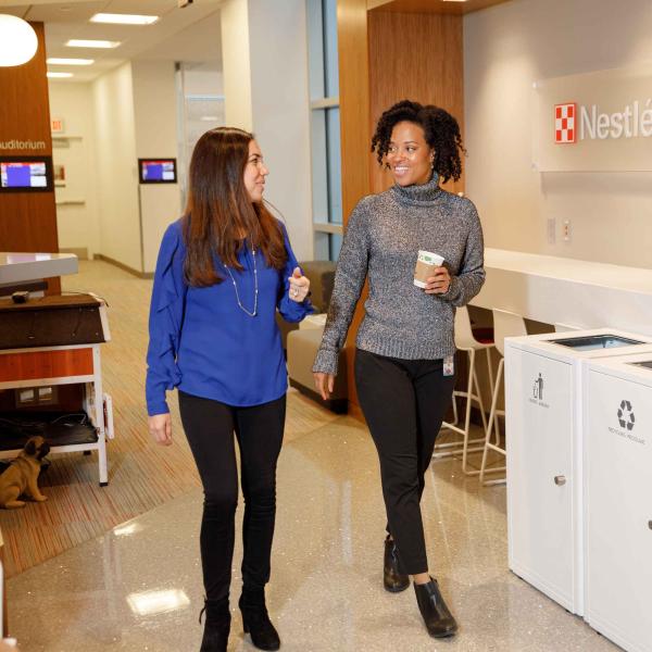 Two women walking in hallway