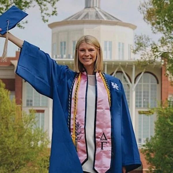 A graduate stands on the university background