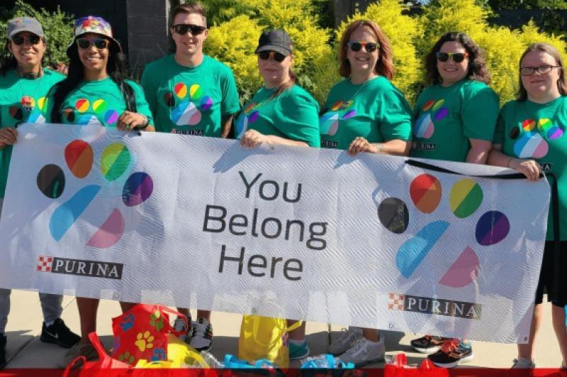 Purina employees holding You Belong Here sign