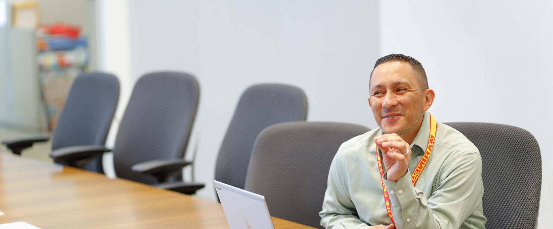 A man sits at the table in the meeting room and talks to someone