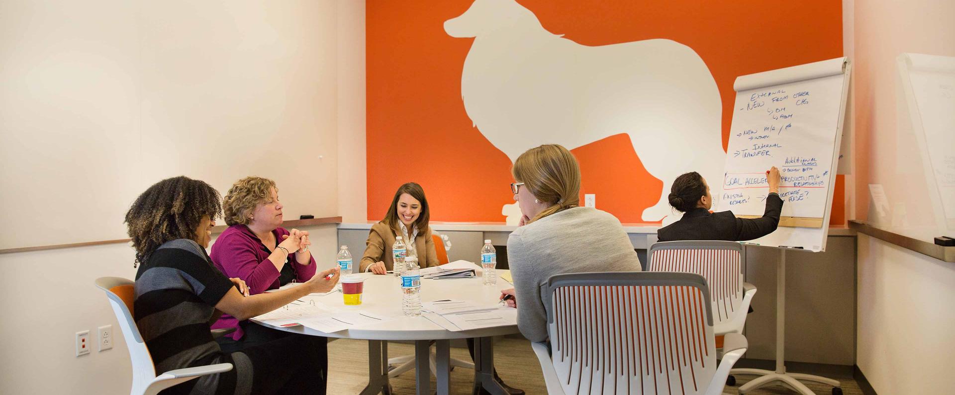 A group of people has a conference in a meeting room