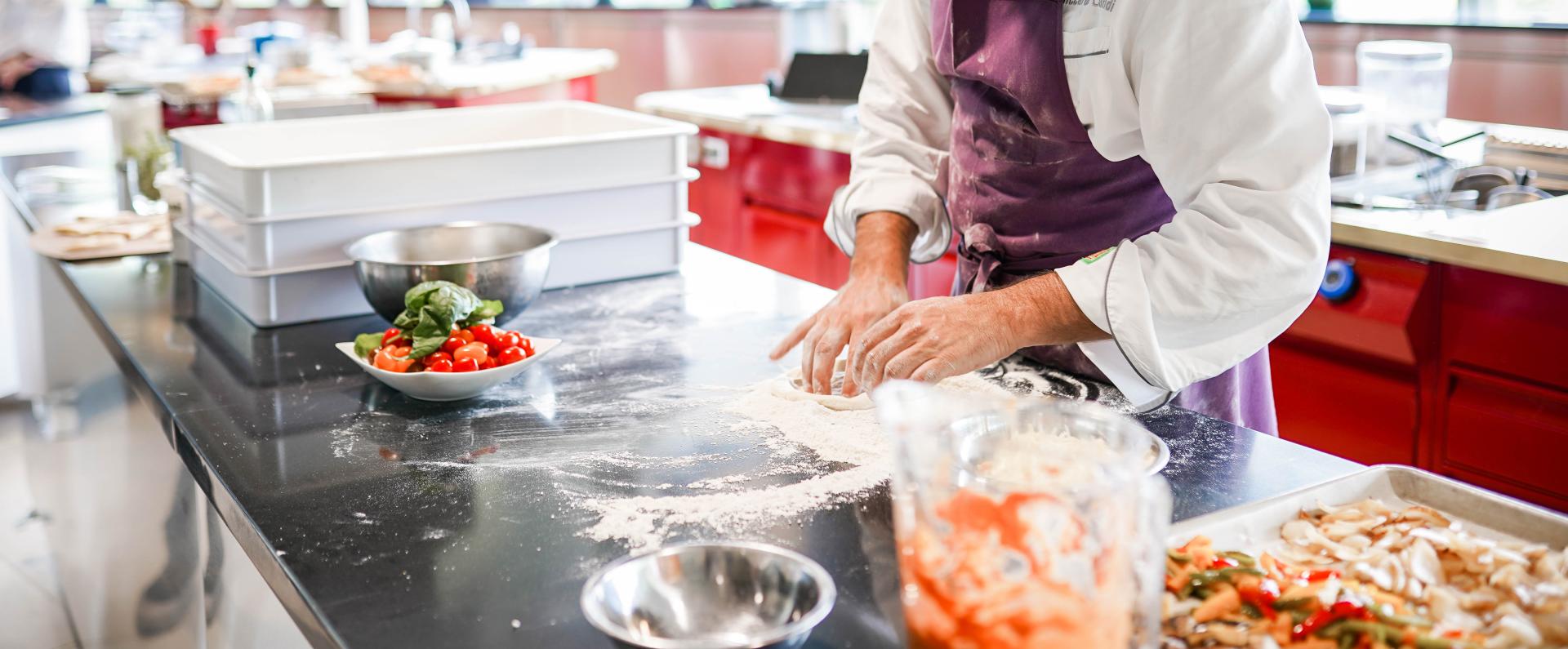 Male chef rolling pizza dough
