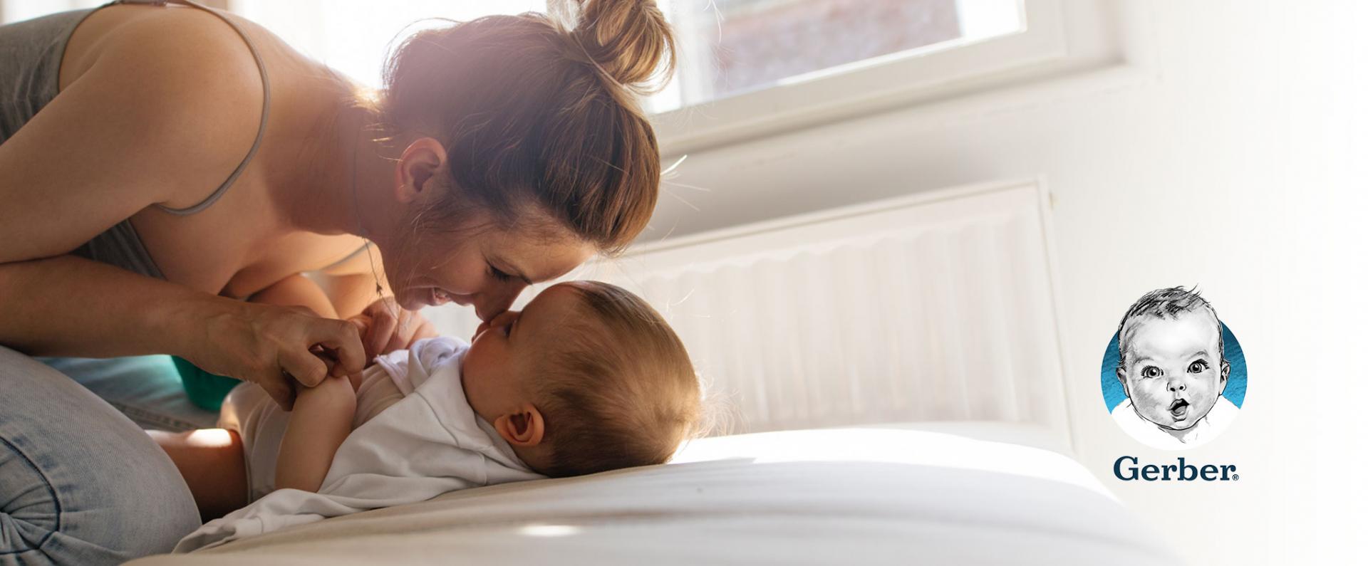 Mom snuggling with her baby on a bed