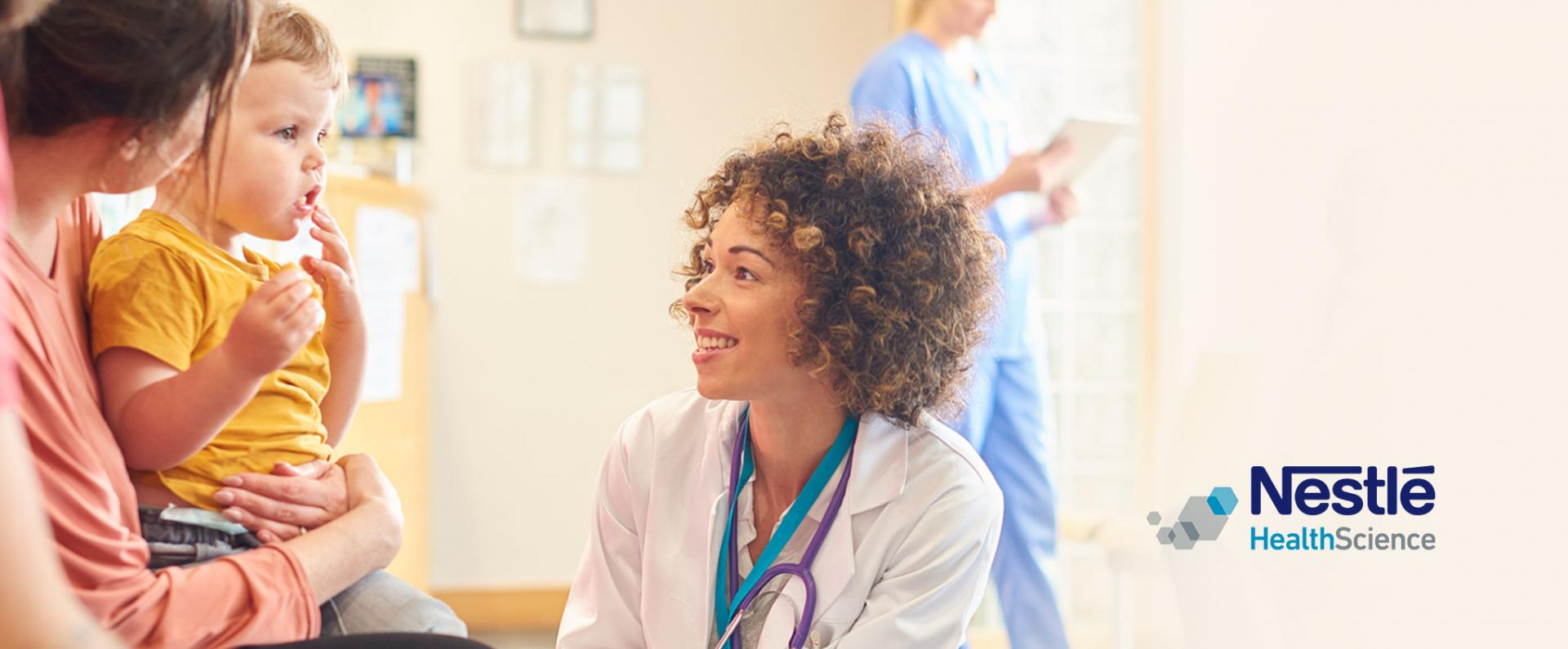 Female doctor talking to a little boy and his parents