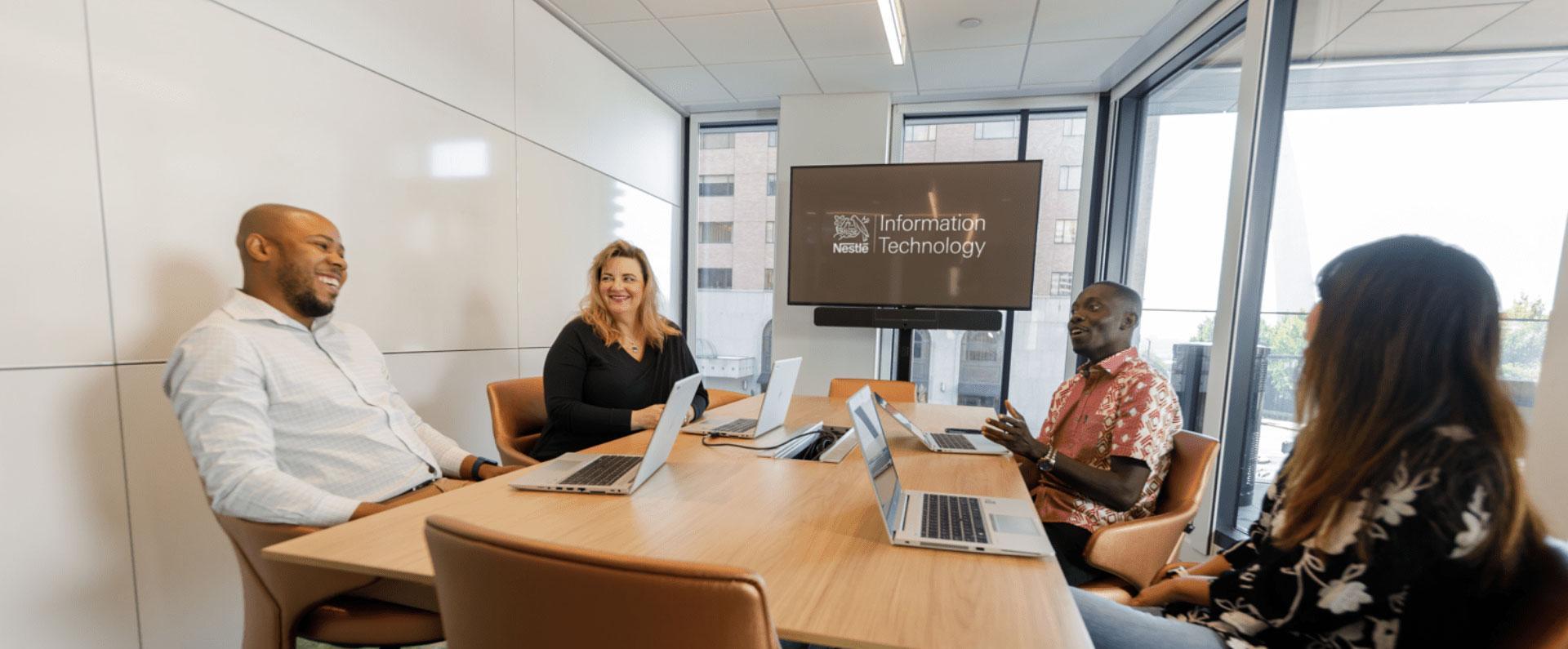 Nestle IT employees meeting in a glass conference room