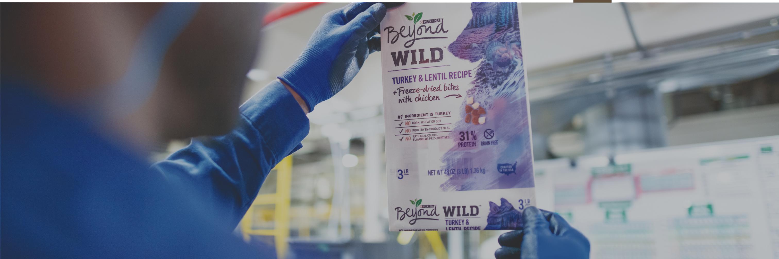 Warehouse worker inspecting a bag of Beyond pet food