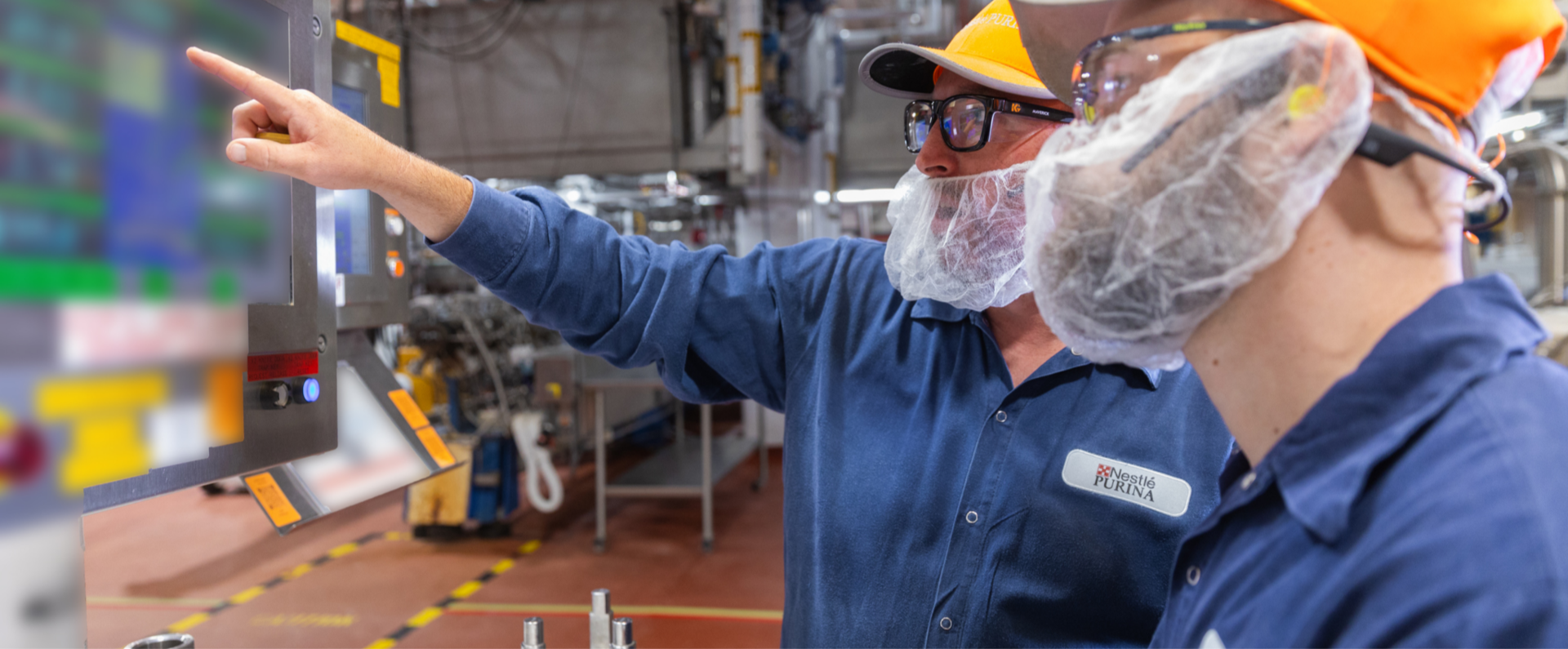 Employees wear personal protective equipment in factory setting